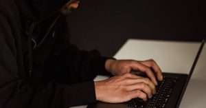 Person studying on a laptop at a tidy desk with notes and coffee preparing for an IT certification