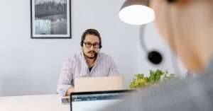 IT support professional using a laptop in a modern workspace taking notes