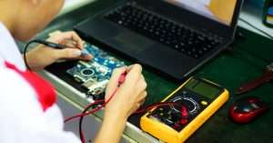 IT support technician working on a laptop in an office, taking a cybersecurity training module