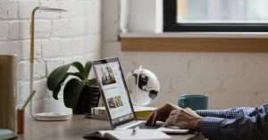 Person working at a laptop with notebook and pen on a tidy desk planning marketing tasks