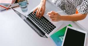 Learner working on a laptop in a tidy home office during a live virtual class