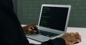 A person studying cybersecurity on a laptop in a modern office