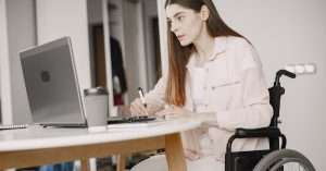 A professional reviewing a web accessibility checklist at a desk with a laptop