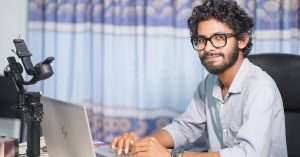 A web developer focusing on code on a laptop in a modern workspace