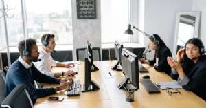 A group of young professionals discussing IT support techniques in an office