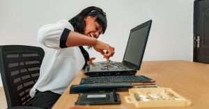 A helpdesk analyst working on a laptop in a modern office