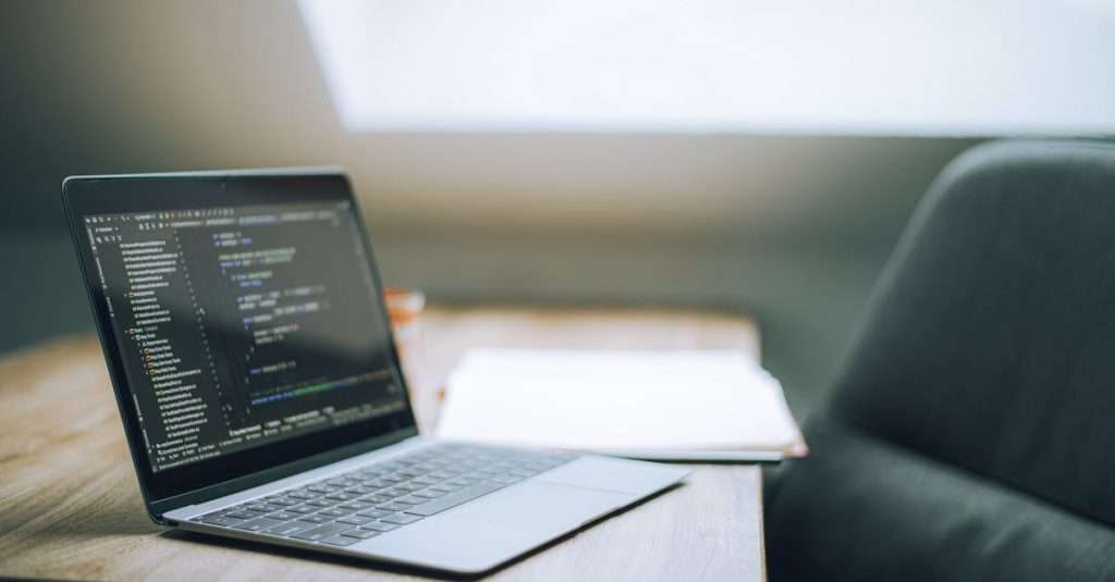 A modern office workspace with a laptop and cloud computing graphics on the screen