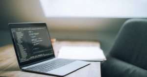 A modern office workspace with a laptop and cloud computing graphics on the screen