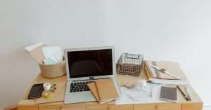 A person working on a laptop in a home office, balancing study and work tasks.