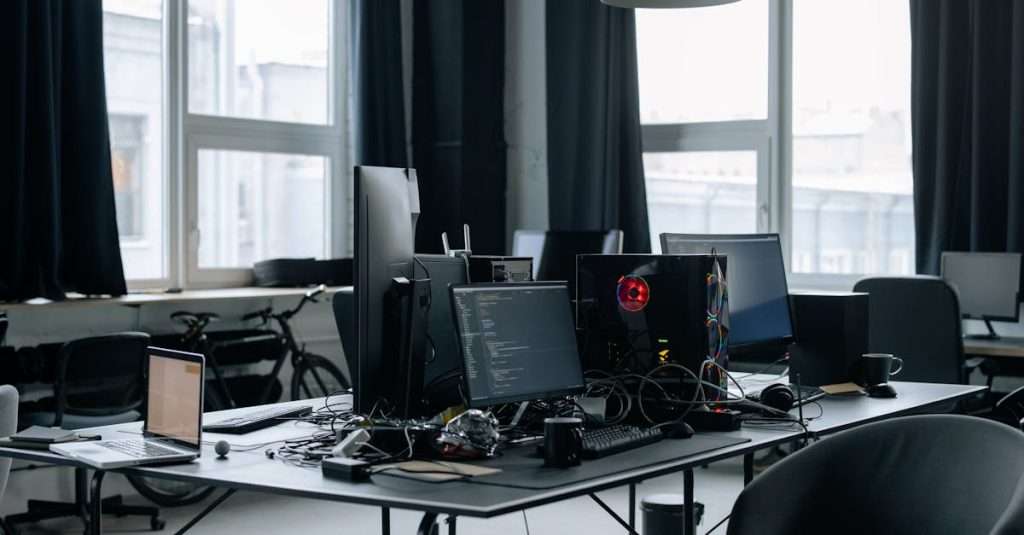 A diverse group of individuals in a modern workspace focused on training with laptops.