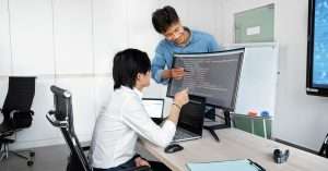 A group of software testing professionals discussing project details at a modern office space