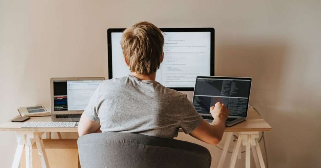 A person working on a laptop in a cozy home office, focused on web development tasks