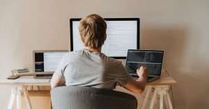 A person working on a laptop in a cozy home office, focused on web development tasks