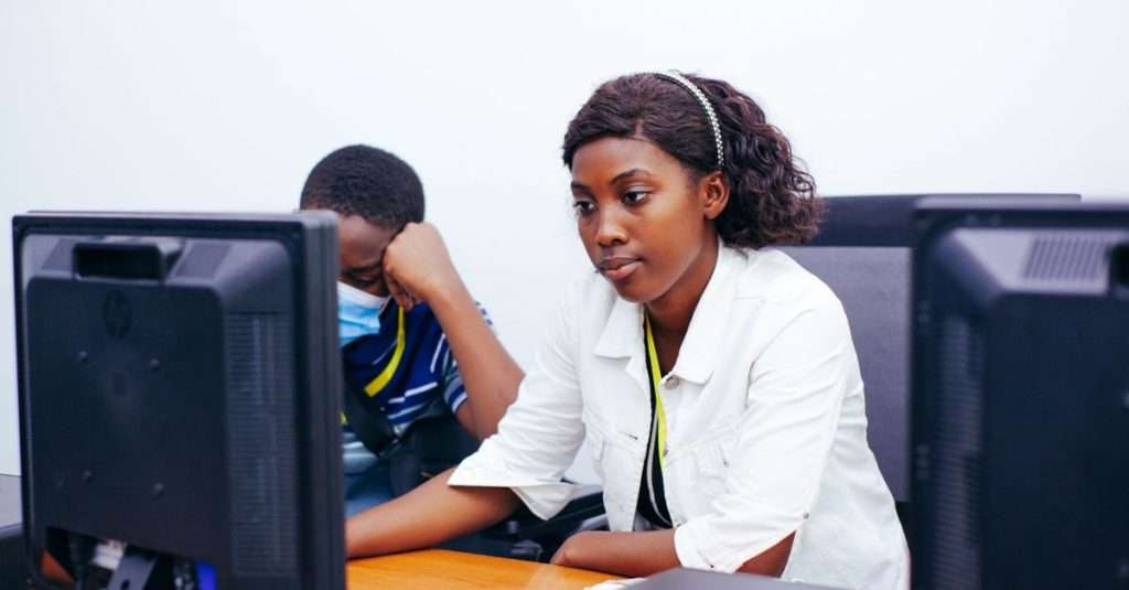 a diverse group participating in an IT training session with laptops in a modern workspace