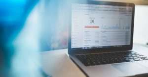 A professional workspace with a laptop and cloud technology concepts