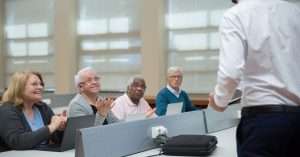 A diverse group of professionals attending a cybersecurity training class with laptops.