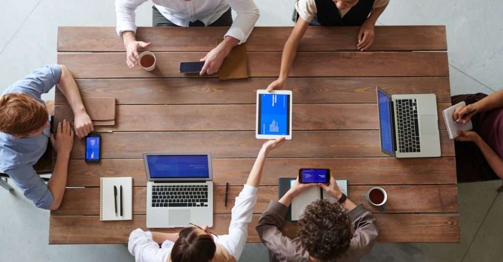 A team of professionals discussing DevOps tools and strategies in an office setting.