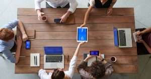 A team of professionals discussing DevOps tools and strategies in an office setting.