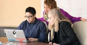 A diverse team of IT professionals discussing project management in a modern office space