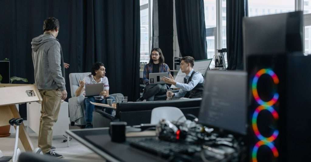 A diverse team of QA professionals engaged in a discussion around software testing strategies.
