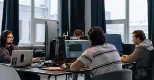 Group of software testers collaborating at desks in a modern office