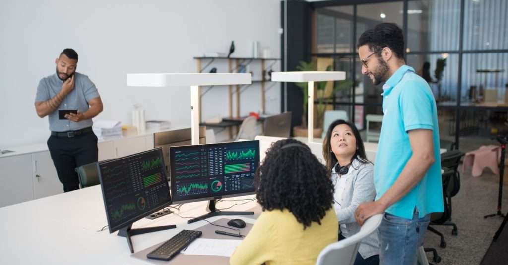 A team working together in an office space with laptops and documents.